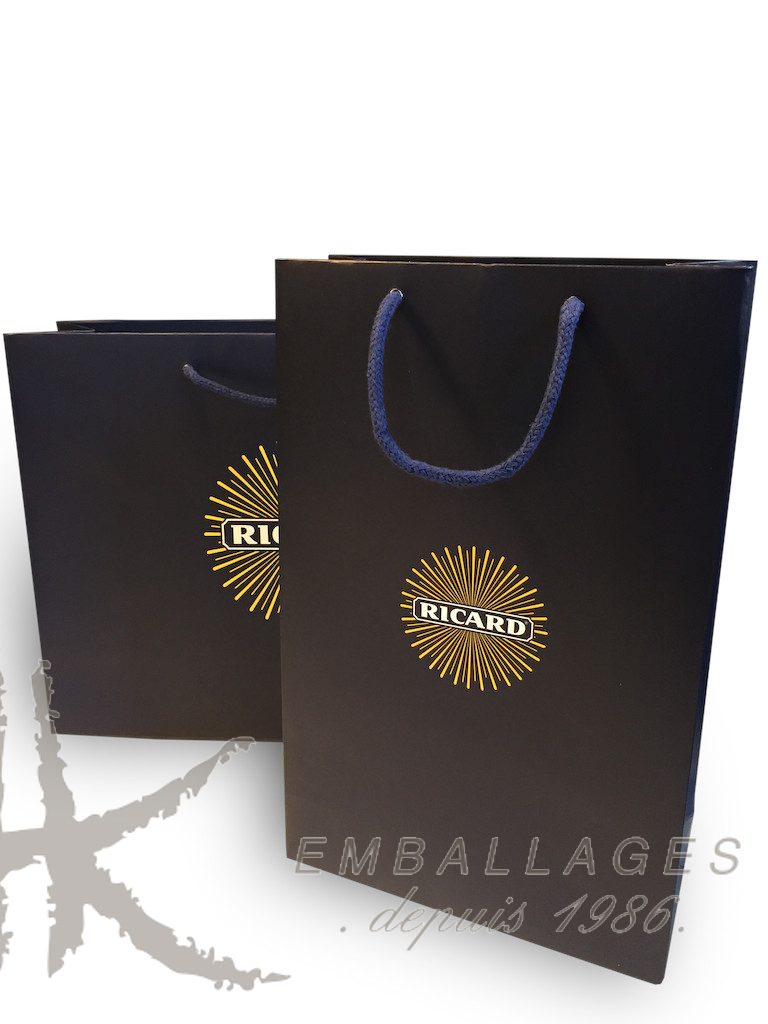 Deux sacs en papier noir avec cordon bleu et logo RICARD or